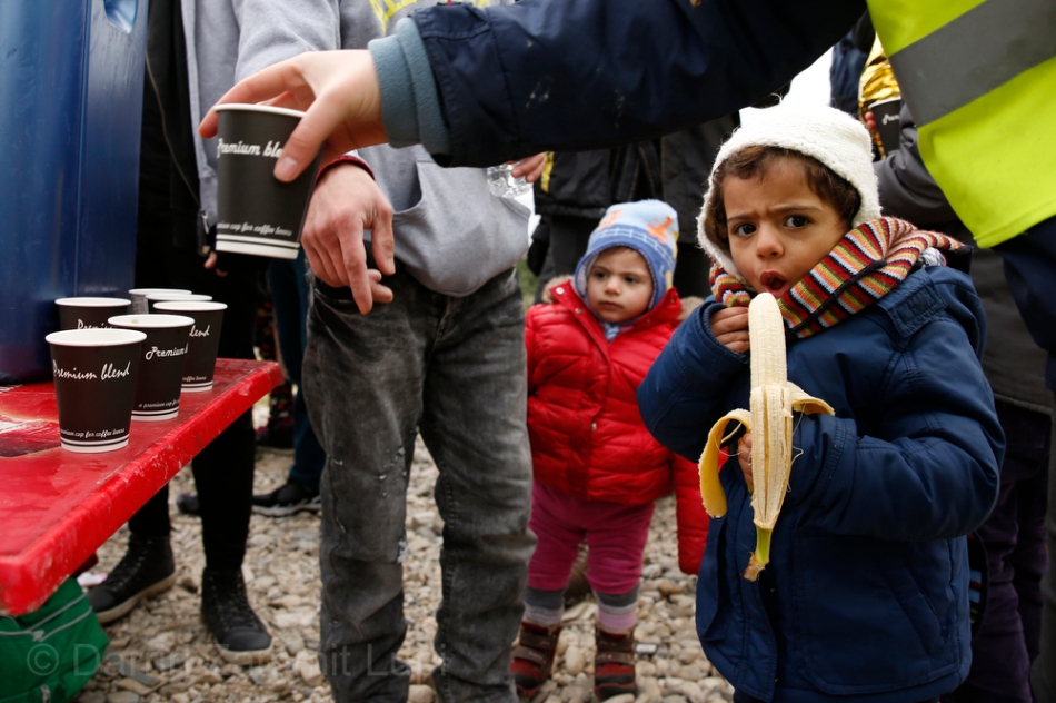 A migrant child eats a banana as hot drinks are distributed moments after the arrival of a rubber dinghy packed with refugees and migrants on a beach on the Greek island of Lesbos